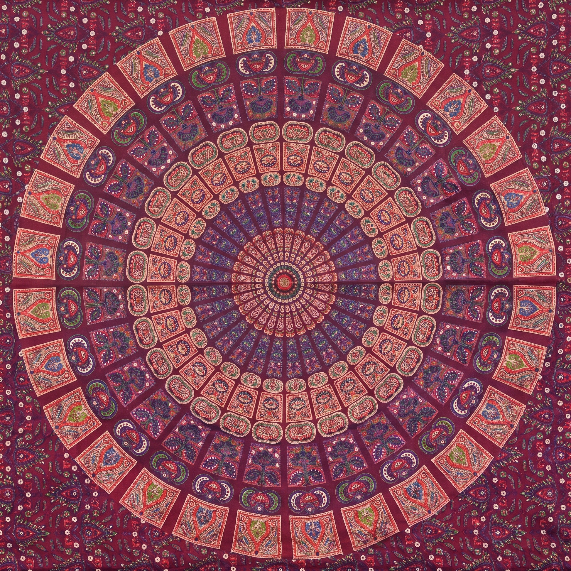 Close detail of hand block printed coral and dusty rose tiles on deep maroon cotton