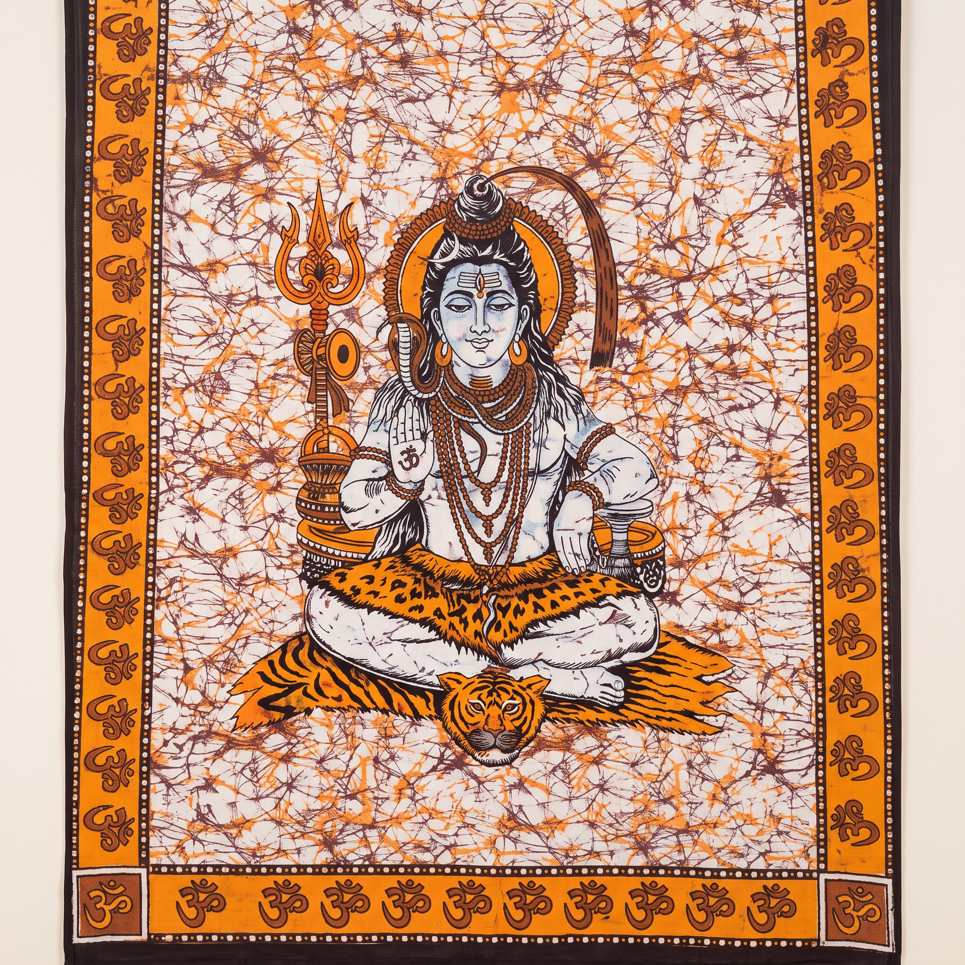 Close detail of the meditating Shiva figure on amber batik cotton